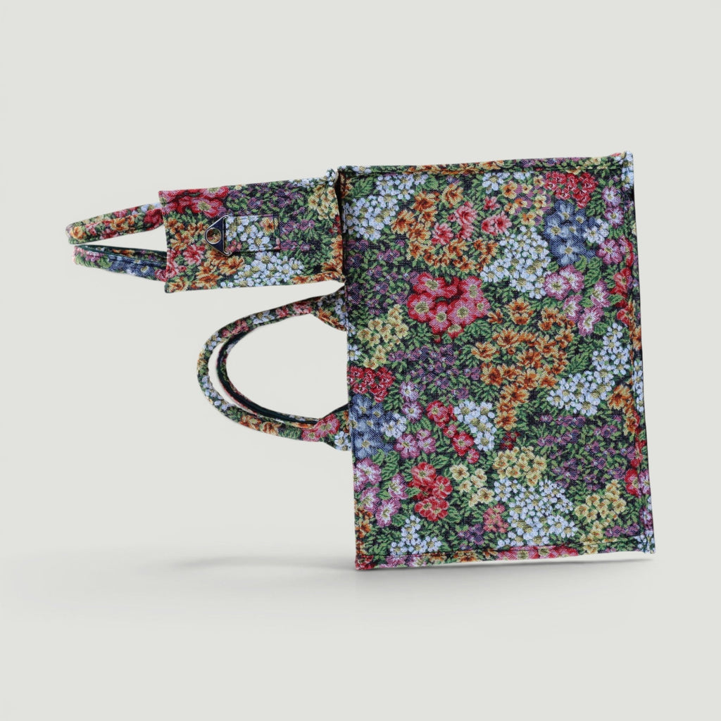 GJEN DESIGN floral tapestry tote bag with vibrant multi-colored flower print and structured fabric handles.