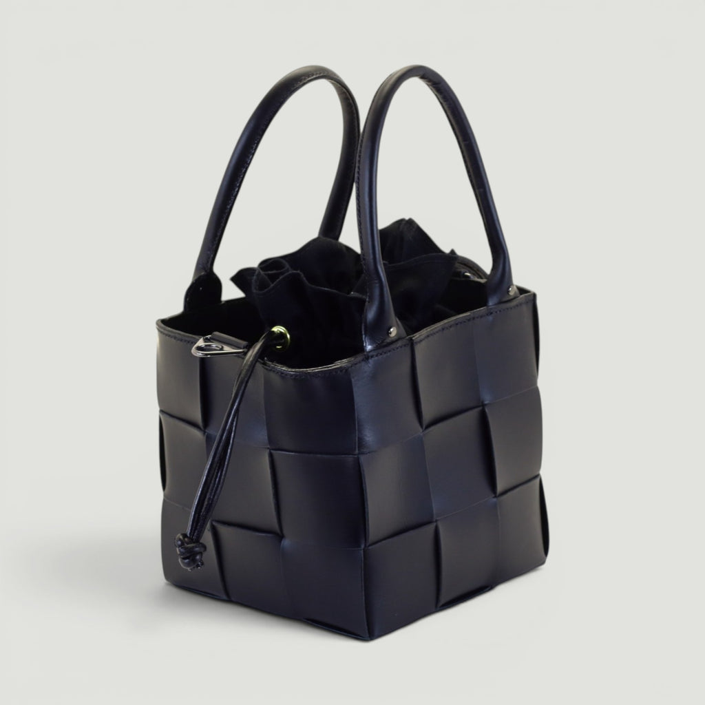 GJEN DESIGN navy blue woven leather bucket handbag with structured silhouette and secure drawstring closure.