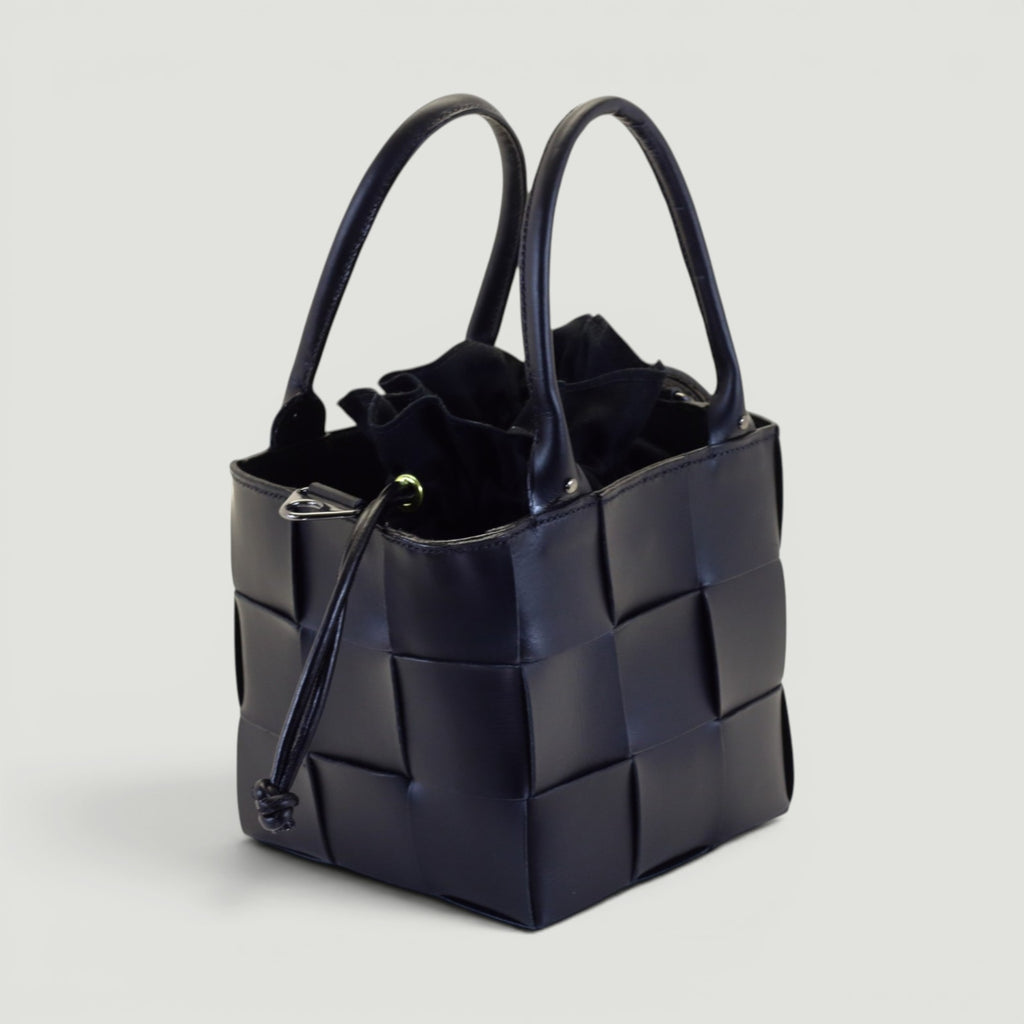 GJEN DESIGN navy blue woven leather bucket handbag with structured silhouette and secure drawstring closure.