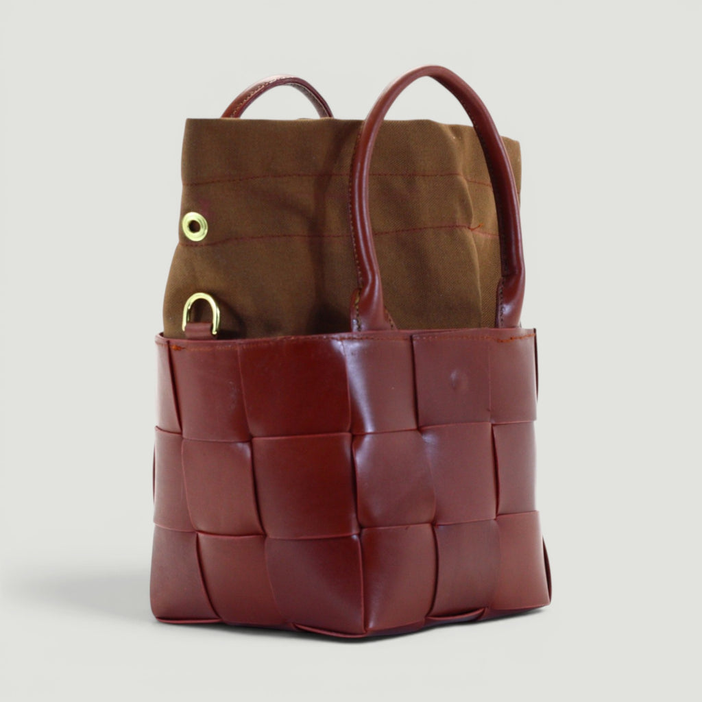 GJEN DESIGN mahogany woven leather bucket tote bag with a brown canvas insert and gold hardware details.