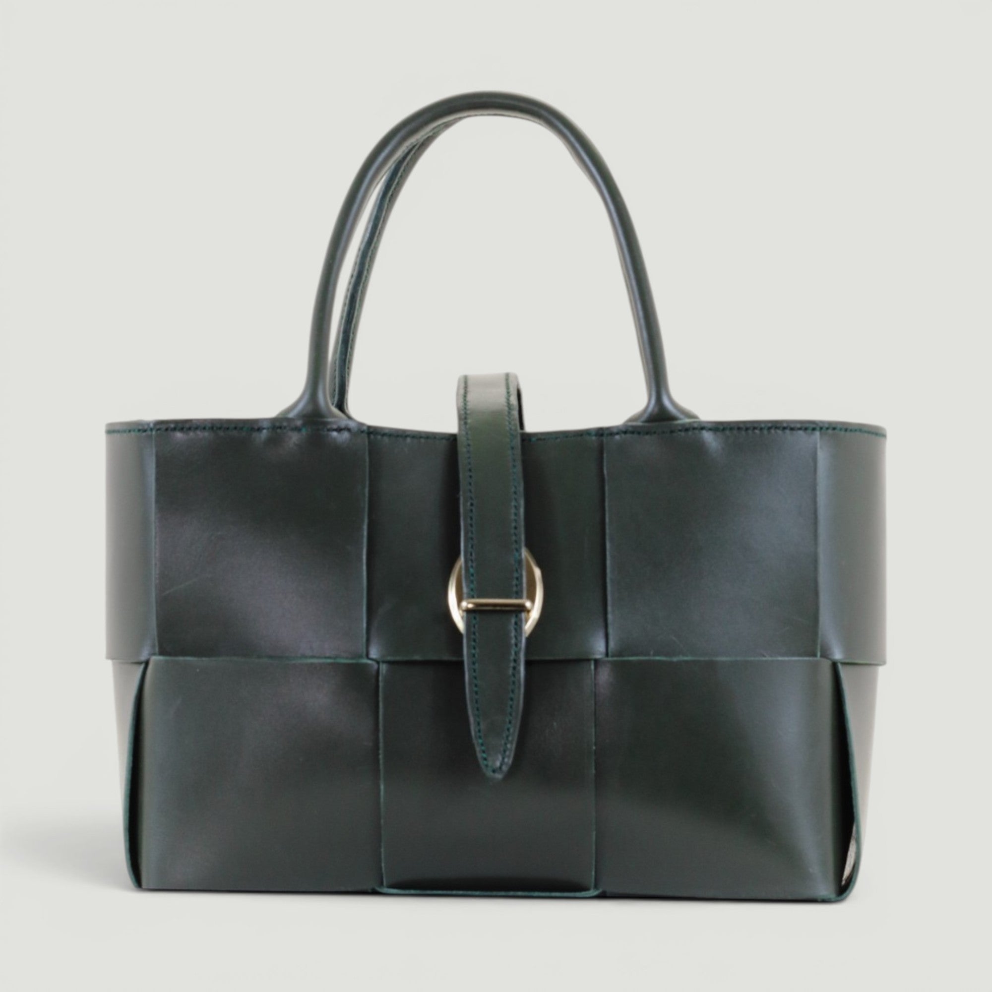 GJEN DESIGN forest green woven leather structured handbag with gold-tone buckle closure and top handles.